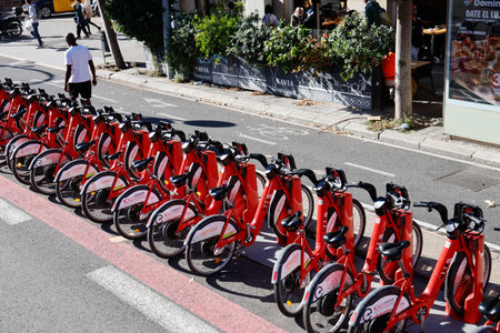 People on bicycles in Barcelona, Spain. Red rental bikes are available in the city of Barcelona.