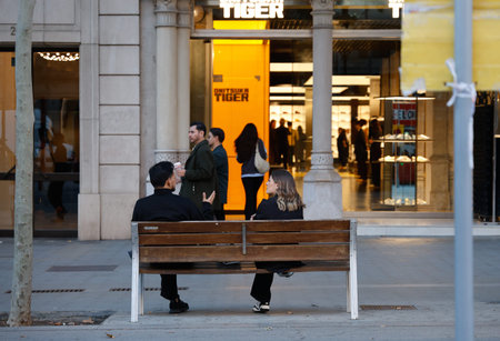 People sitting on a bench in Barcelona.