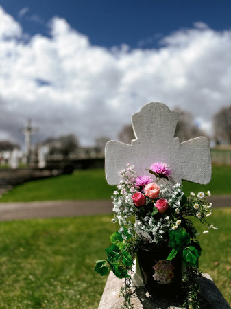 Flowers on a grave in a cemetery in Quebec.