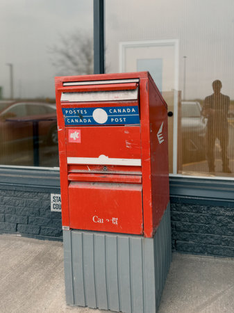 Quebec, Canada. Typical post box on the street in Quebec. Canada Post. Post box in front of the entrance door of a post office, Canada.