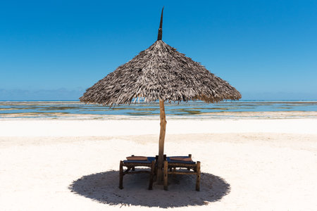 Beach chair and umbrella on white sand beach with blue sky background, Mauritius Islandの写真素材