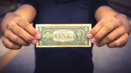 Man holding a US dollar bill.