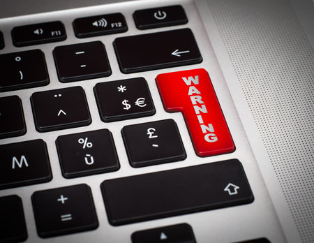 close up of a Red button with warning word on the keyboard .