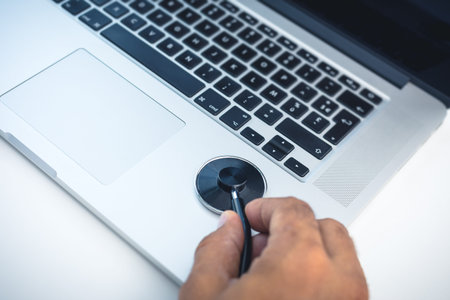 Man hand holding a stethoscope checking laptop , concept of safety and protect computer from viruses...