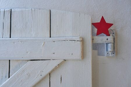 Red christmas star nicely decorated on a white shabby wooden shutter, scandinavian styleの写真素材