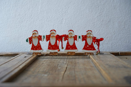 Close up of a group of father christmas nicely decorated on a used cracky wooden elementの写真素材
