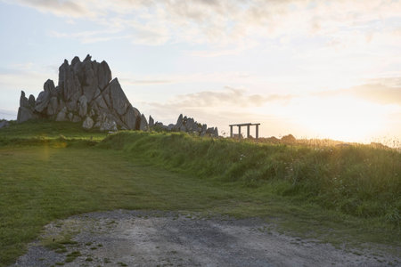 Idyllic peaceful landscape with view to a rock, grass in the foreground, dusk