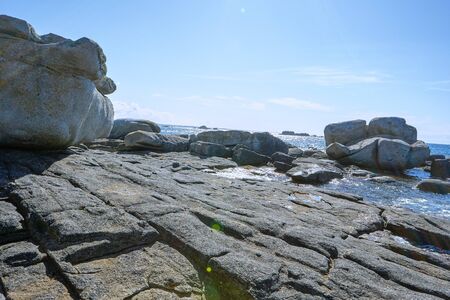 Waterside of Brittany with rock formation and sun reflections on the seaの写真素材
