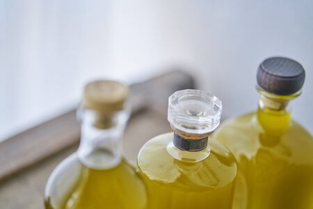 glass bottles with  fresh yellow  golden liquid oil or  juice in sunny summer atmospher in country style moodの写真素材