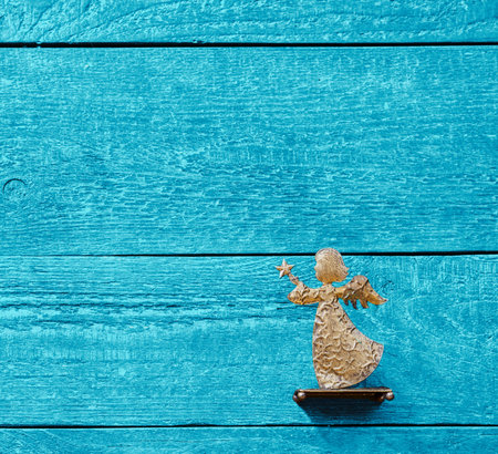 Colourful background of textured wooden planks in blue with a golden angel and copy spaceの写真素材