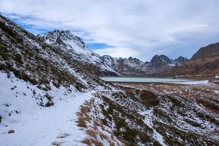 hiking trail in the mountains with snow, silvretta in austria with a view of the damの写真素材