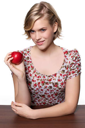 Young woman holding up a red appleの写真素材