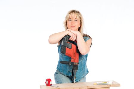 Young blonde woman works with a cordless electric screwdriverの写真素材