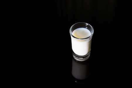 A glass of milk on black background / still life imageの写真素材