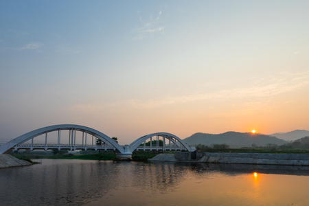 The white bridge backdrop orange sky at the morning in Lamphun. Thailandの写真素材