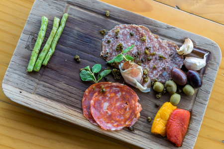 Salami and vegetables on a wood board