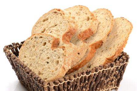 sliced loaf of bread in a basket isolated on white