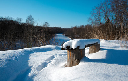 Bench covered with snow in the ruralの写真素材