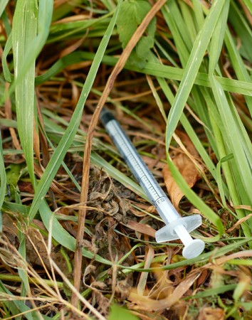 Used syringe on the grass.の写真素材