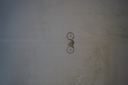 cement wall and electrical outlet in a room, closeup of photo