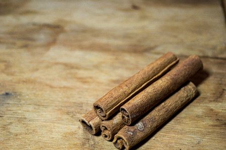 Four cinnamon sticks lying on an oak plankの写真素材