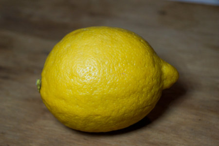 Yellow lemon lying on oak board, dark backgroundの写真素材