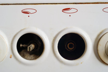 Knobs turning on burners on an old gas stove close-up