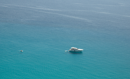 Small boat on the crystal clear sea near the town of Tropea region Calabria - Italyの写真素材