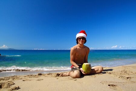Santa Claus with coco on beach of oceanの写真素材