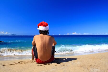 Santa Claus from the back on beach of oceanの写真素材