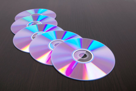 Dvd disks on black wooden table,closed-up