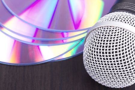 Vocal microphone and audio discs, closed-up on black tableの写真素材