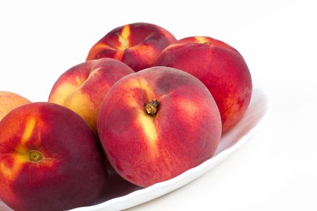 Peaches on white plate, closed-up on white の写真素材