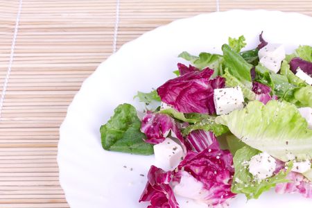 Salad of leafs and sheep cheese on plate,closed-up on wooden matの写真素材