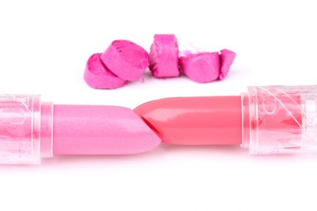 Two whole  and one sliced  lipsticks in distance, closed-up on whiteの写真素材