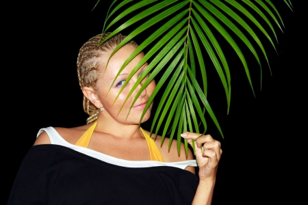 Girl with french plaits holding palm leafの写真素材