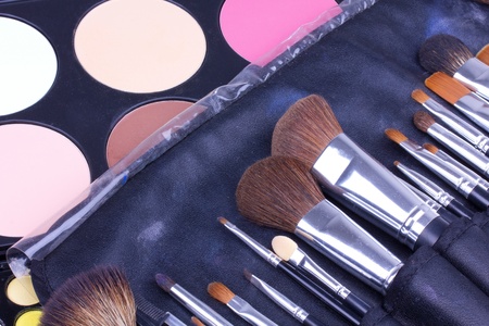 Make-up brushes in leather case on eyeshadows palettes, closed-upの写真素材