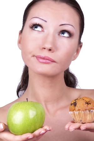 Woman with apple and cake in hands, closed-up portraitの写真素材