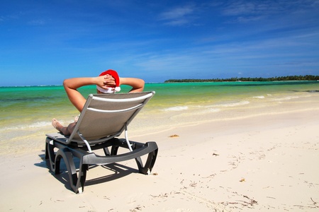 Santa on chaise longue on tropical beach, caribbean seaの写真素材