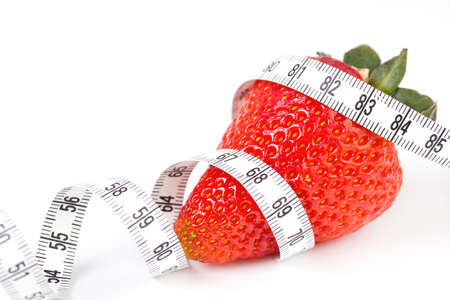 Strawberry with measure tape, closeup on whiteの写真素材
