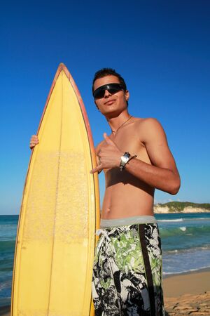 Surfer with surf board on tropical beachの写真素材