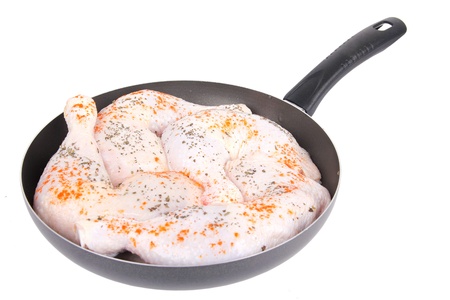 Raw chicken with spice ,on frying pan, closeup on whiteの写真素材