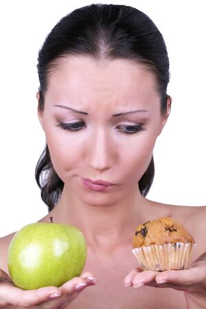 Girl with apple and cake in hands, closeup portrait の写真素材
