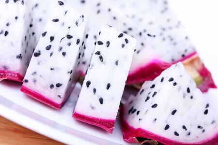 Cutted dragon fruit on wooden  board, closeup on whiteの写真素材