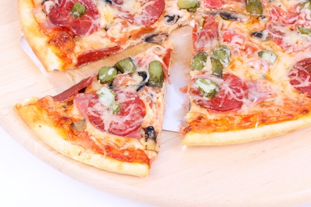 Cutted pizza on wooden board, closeup on whiteの写真素材