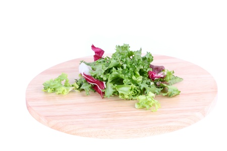 Salad leafs on wooden board isolated on whiteの写真素材