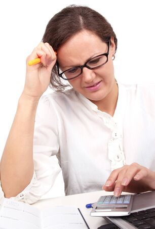 Businesswoman holding pencil in hand, sitting in officeの写真素材