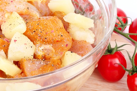 Cutted chicken breast fillet with pineapple in glass bowl, closeupの写真素材