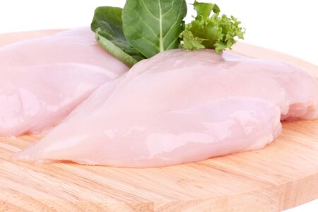 Raw uncooked chicken fillet on wooden board, closeupの写真素材