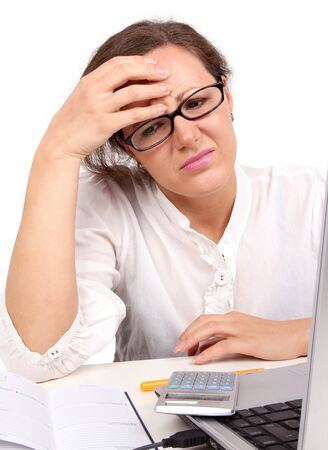 Sad businesswoman holding her head, sitting in officeの写真素材